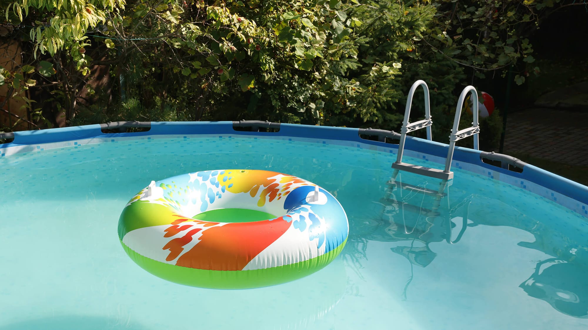 A colorful swimming ring floats in an above-ground pool