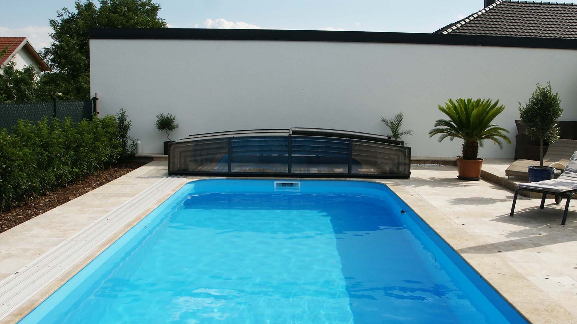 A modern swimming pool with a retractable cover, illustrating a durable pool cover solution.