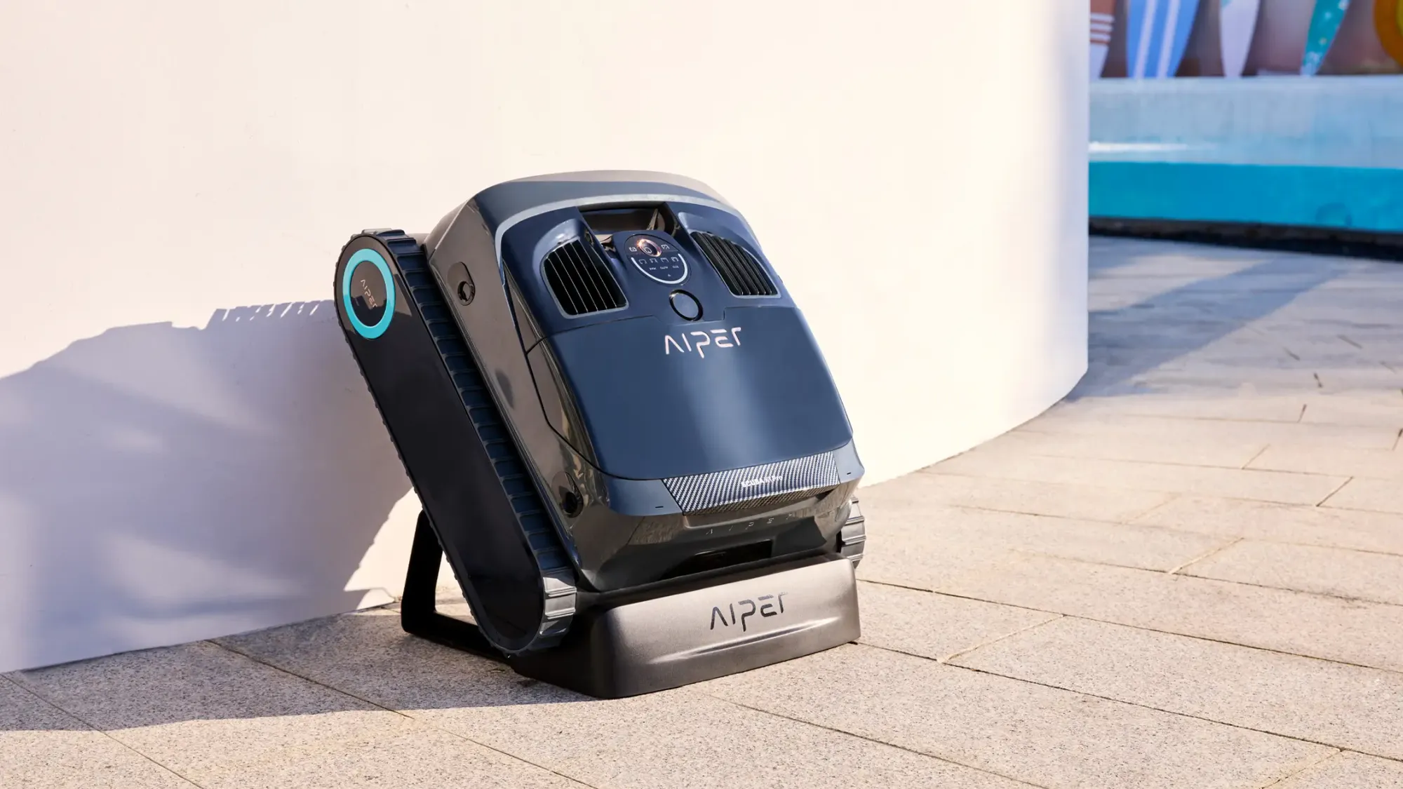 Robotic pool cleaner docked for charging beside pool