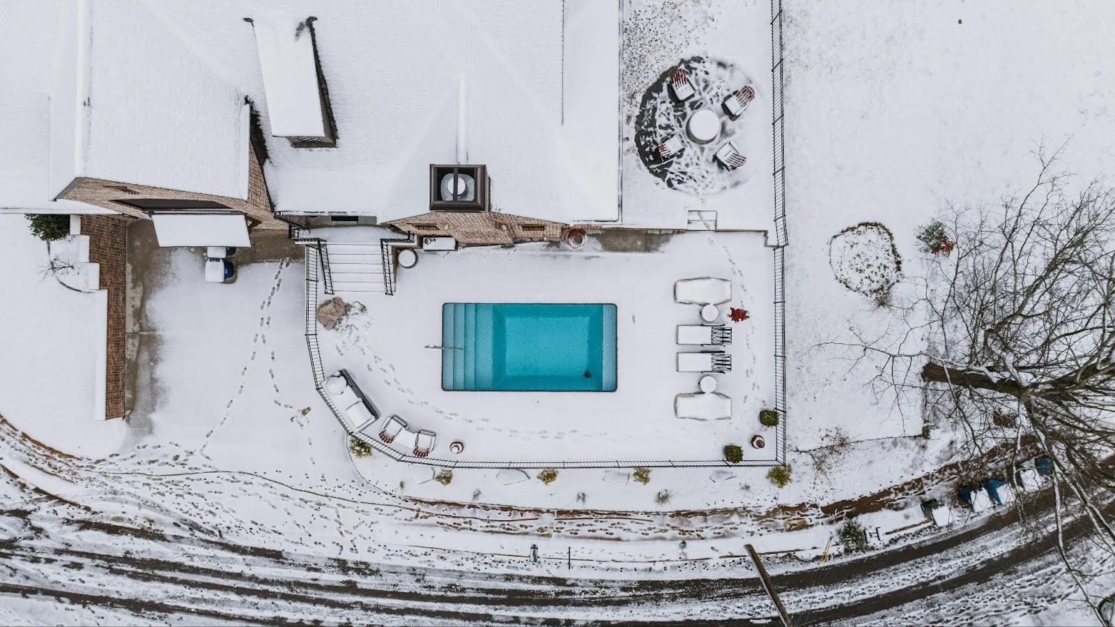 Vista cenital de una piscina privada en invierno rodeada de nieve