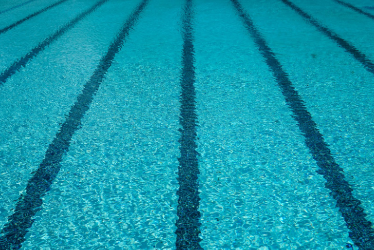 Agua azul clara de piscina con líneas de carril