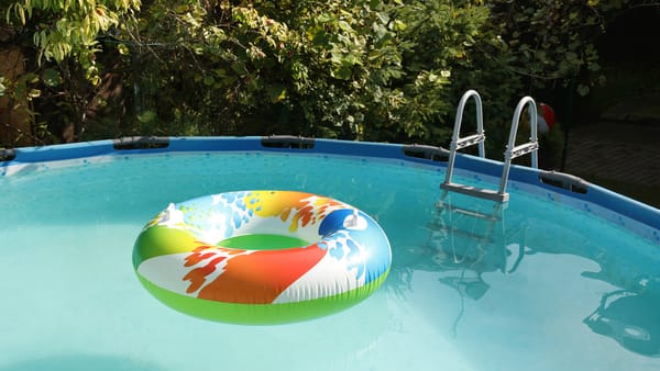 A colorful swimming ring floats in an above-ground pool