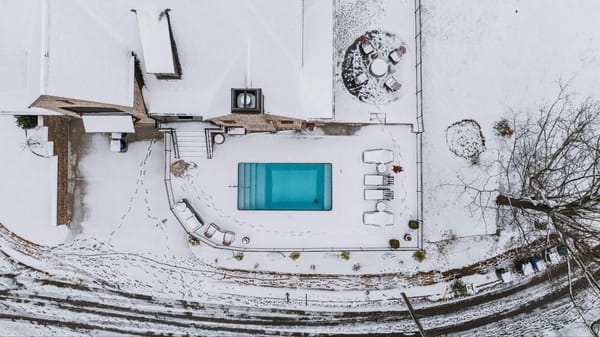Vista cenital de una piscina privada en invierno rodeada de nieve